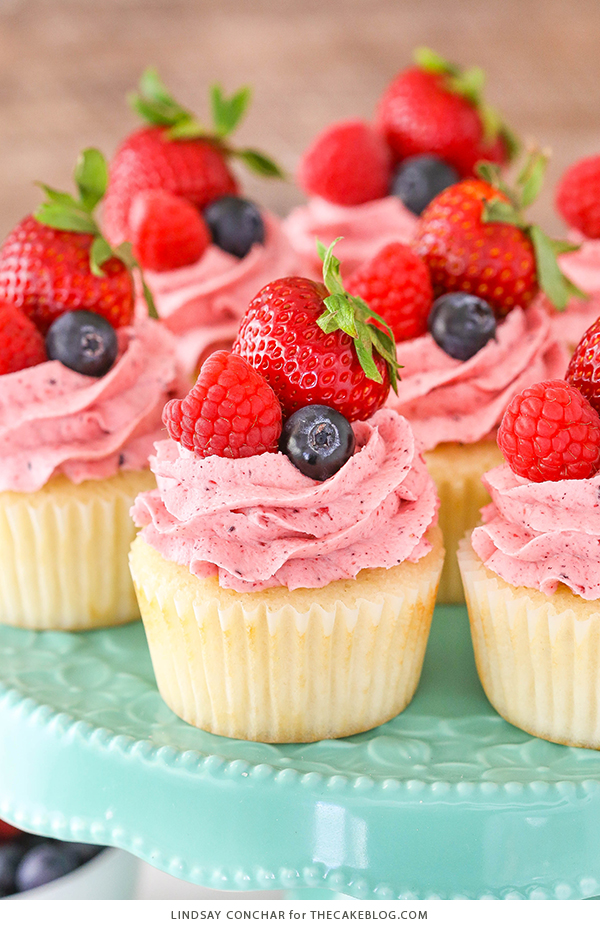 Berries and Cream Cupcakes - mixed berry buttercream paired with a moist vanilla cupcake stuffed with whipped cream cheese filling, topped with fresh strawberries, raspberries and blueberries | by Lindsay Conchar for TheCakeBlog.com