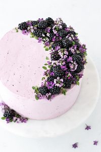 Blackberry Lime Cake - tender cake infused with lime zest, frosted with blackberry buttercream, topped with fresh blackberries and edible flowers | by Carrie Sellman for TheCakeBlog.com