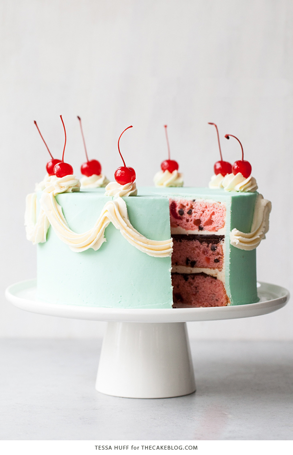 Cherry Chip Cake - maraschino cherry cake studded with chocolate chips, layered with chocolate ganache and finished with a whipped vanilla buttercream frosting | by Tessa Huff for TheCakeBlog.com