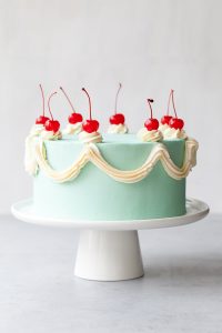 Cherry Chip Cake - maraschino cherry cake studded with chocolate chips, layered with chocolate ganache and finished with a whipped vanilla buttercream frosting | by Tessa Huff for TheCakeBlog.com