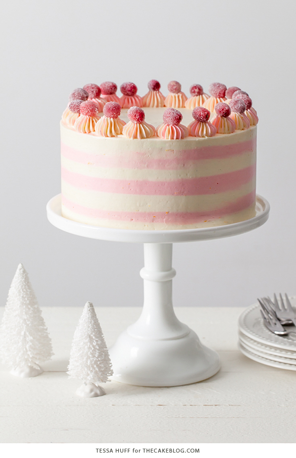 Cranberry Orange Spice Cake - orange cake studded with cranberries topped with white chocolate orange frosting in festive pink and white buttercream stripes | by Tessa Huff for TheCakeBlog.com