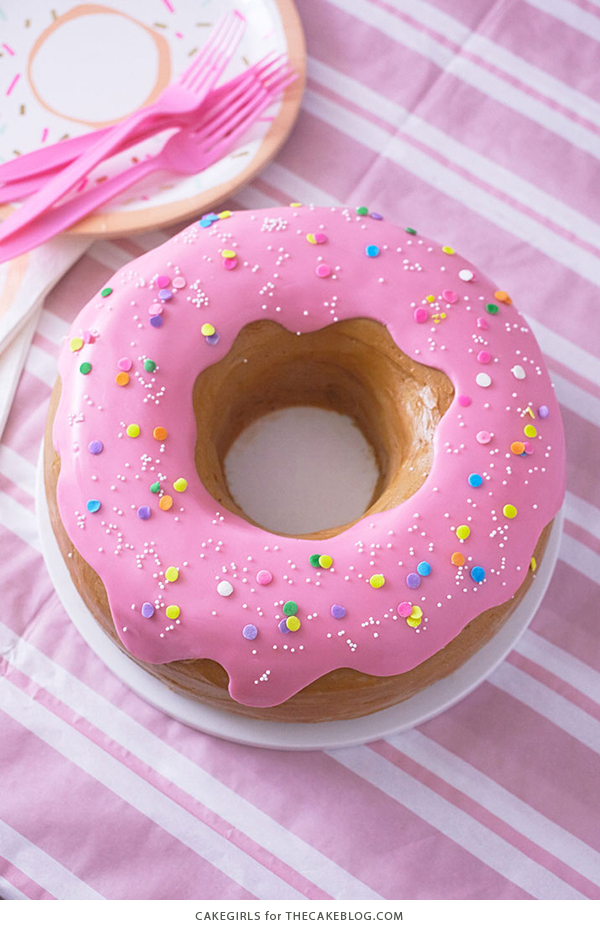 Giant Donut Cake! Learn how to make this adorable, sprinkle-coated, giant donut cake with a simple step-by-step tutorial | by Cakegirls for TheCakeBlog.com
