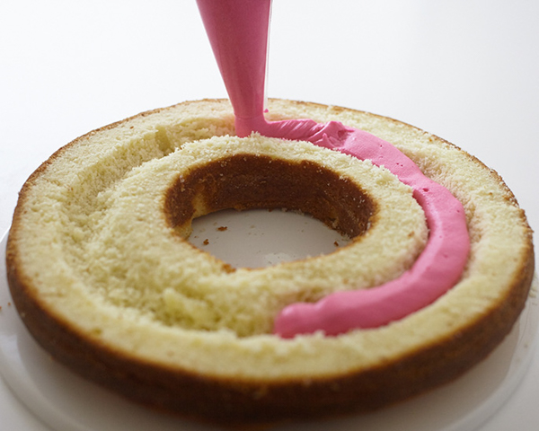 Giant Donut Cake! Learn how to make this adorable, sprinkle-coated, giant donut cake with a simple step-by-step tutorial | by Cakegirls for TheCakeBlog.com