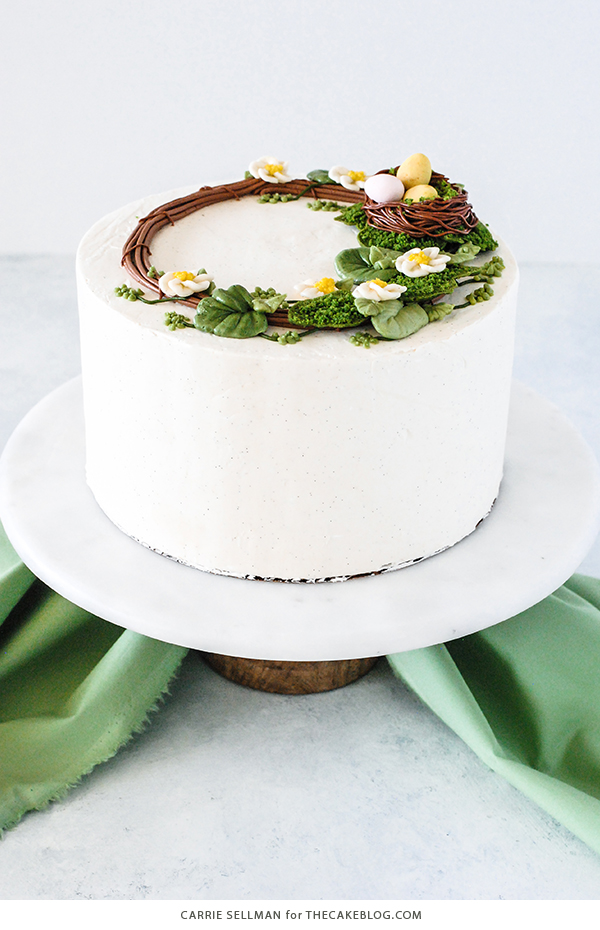 Spring Wreath Cake - how to make a buttercream wreath cake a bird's nest, cherry blossoms, green berries and cookie moss | by Carrie Sellman for TheCakeBlog.com #easter #easterdinnerideas #mothersday #cake