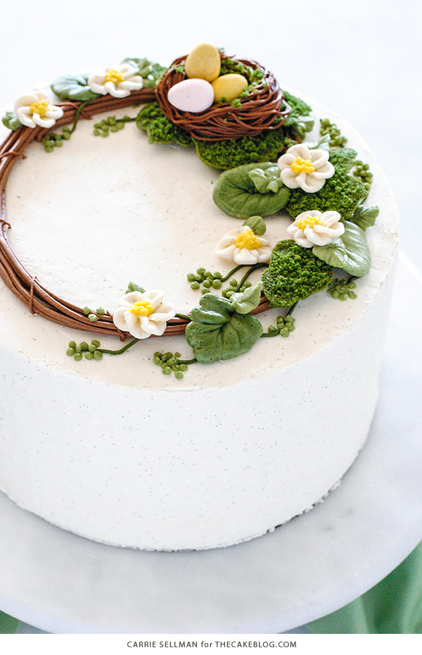Spring Wreath Cake - how to make a buttercream wreath cake a bird's nest, cherry blossoms, green berries and cookie moss | by Carrie Sellman for TheCakeBlog.com #easter #easterdinnerideas #mothersday #cake