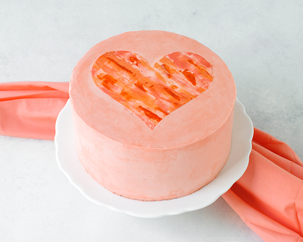 Watercolor Heart Cake - how to paint a watercolor heart cake using buttercream frosting and a parchment paper stencil | by Carrie Sellman for TheCakeBlog.com